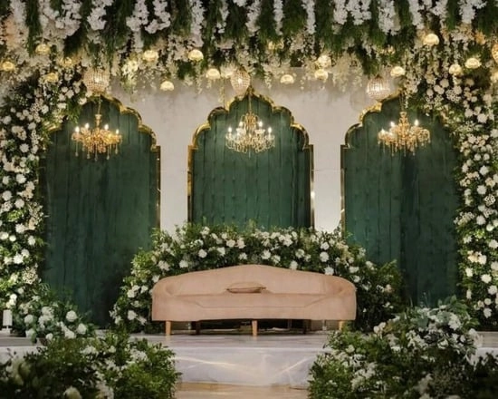 Wedding stage with green arches.