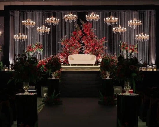 Elegant wedding stage with red flowers.